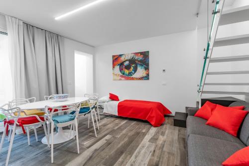 ein Wohnzimmer mit einem Tisch, Stühlen und einem Bett in der Unterkunft Palazzo Ruzante Padova - Barcellona Apt in Padua