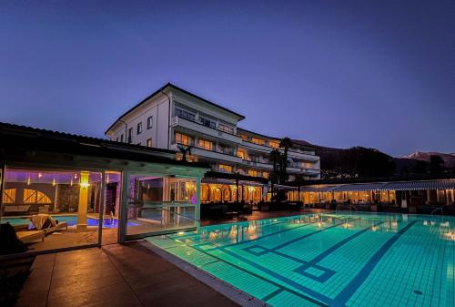 a large swimming pool in front of a building at Parkhotel Delta, Wellbeing Resort in Ascona