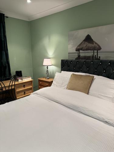ein Schlafzimmer mit einem großen weißen Bett und einer Lampe in der Unterkunft Windsor Wine and Dine in Chertsey