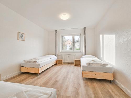 a room with two beds and a window at Tolstov Apartments - Monteurwohnung - 2 Schlafzimmer - Küche - Balkon - Waschmaschine - 25 Min zur Messe DUS in Heiligenhaus