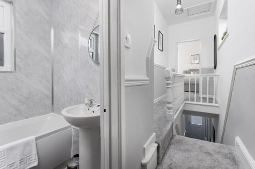 a white bathroom with a sink and a tub and a toilet at Host Liverpool - Anfield Gem, pet-friendly with garden in Liverpool