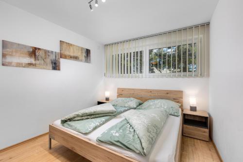 1 dormitorio con 1 cama y 2 ventanas en Gerlitzenzeit en Treffen