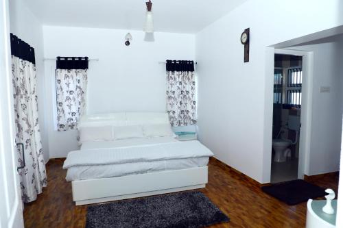 a living room with a white couch and curtains at HAILSTONE HOME STAY in Ooty