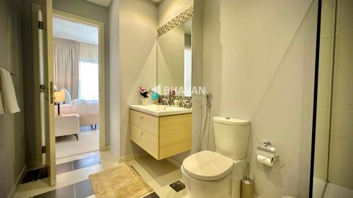 ein Badezimmer mit einem WC, einem Waschbecken und einem Spiegel in der Unterkunft Calm Chaos 4 BR Villa with maid Room in Damac Hills 2 in Dubai