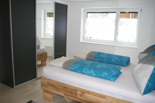 a bedroom with a bed with blue pillows on it at Sellraintaler Auszeit 2 in Sellrain