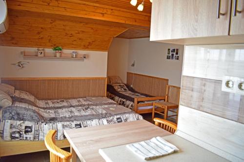 ポロスローにあるTündérfátyol vendégházのベッド2台、テーブル、椅子が備わる客室です。