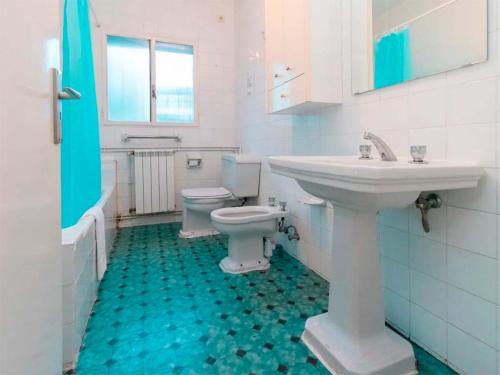 a white bathroom with a sink and a toilet at Complejo Bubal Formigal 3000 in Búbal