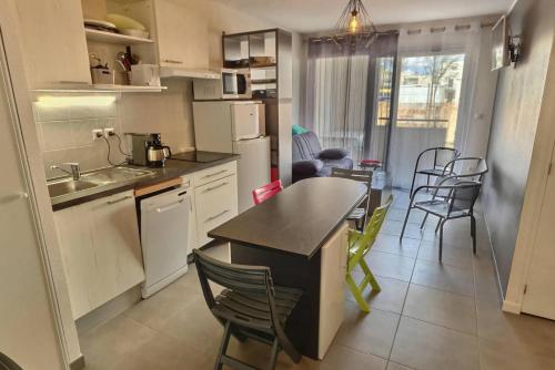 une cuisine avec une table et des chaises dans une pièce dans l'établissement Perra, à Sérignan