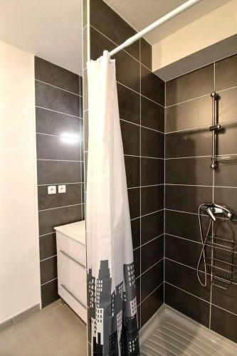 La salle de bains est pourvue d'une douche avec rideau de douche blanc. dans l'établissement Perra, à Sérignan