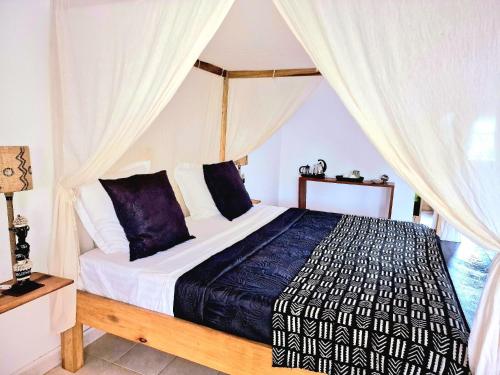 a bedroom with a bed with a canopy at Ginger Villa Somone in Somone
