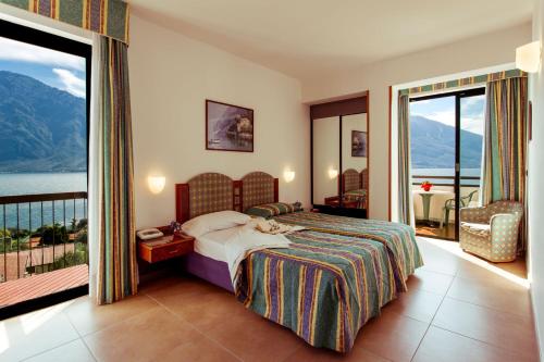 ein Hotelzimmer mit einem Bett und einem Balkon in der Unterkunft Hotel Ilma Lake Garda Resort in Limone sul Garda