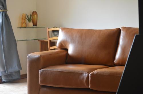 um sofá de couro castanho sentado numa sala de estar em Bloom em Bloemfontein