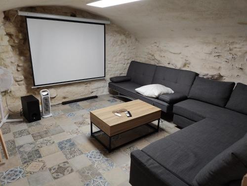 a living room with a couch and a blank screen at Maison 3 chambres 100m du Théâtre Antique avec salle cinéma in Orange