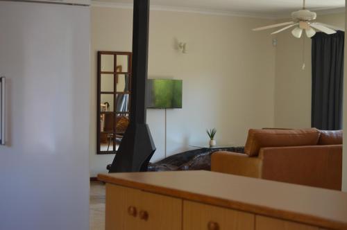 a living room with a couch and a ceiling fan at Bloom in Bloemfontein