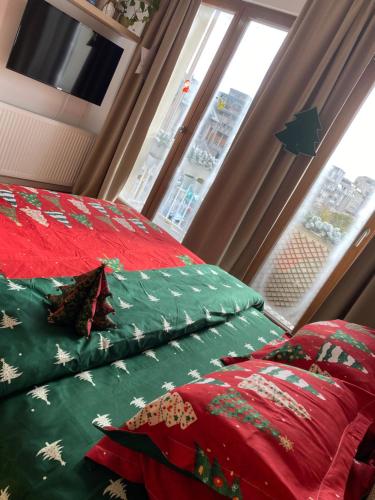 a bedroom with a bed with green and red sheets at Sweet cozy Ultracentral in Craiova