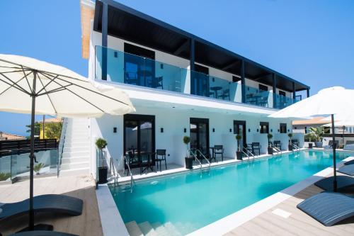 a swimming pool with chairs and umbrellas next to a building at Solvio Boutique Hotel in Lefkada
