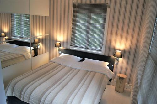 1 dormitorio con 1 cama grande y 2 ventanas en Chalet de Vasterival, en Varengeville-sur-Mer