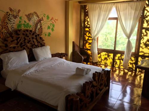 a bedroom with a large bed with a wooden headboard at Hosteria Hachacaspi in Puyo