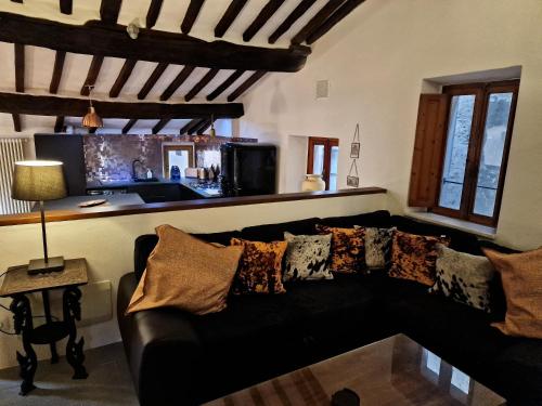 a living room with a black couch with pillows at The Loft in Barga