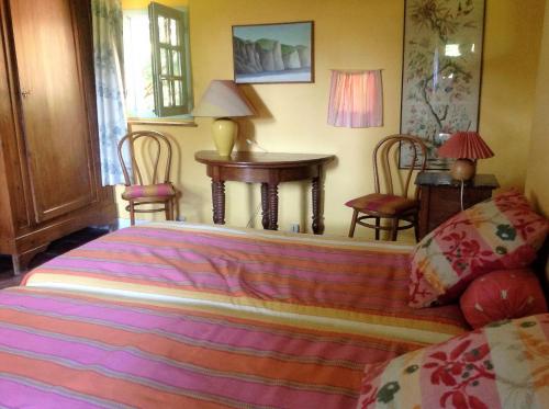 une chambre avec un lit, une table et des chaises dans l'établissement Petite Maison, à Varengeville-sur-Mer