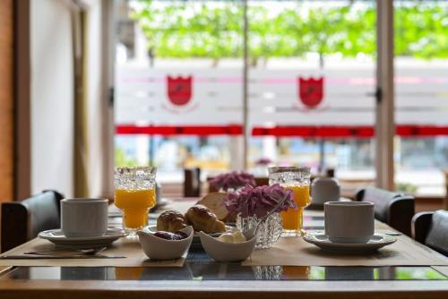 uma mesa com comida e copos de sumo de laranja em Hotel San Carlos em General Juan Madariaga