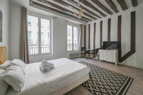 une chambre avec un lit avec un ours en peluche dessus dans l'établissement Cléry 32, à Paris