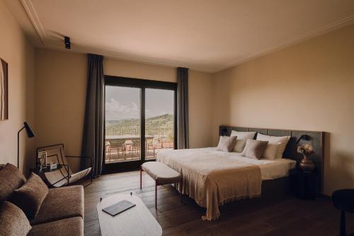 a bedroom with a large bed and a large window at Aethos Saragano in Saragano