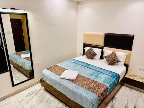 a bedroom with a bed and a mirror at GREENS ELITE in Chennai