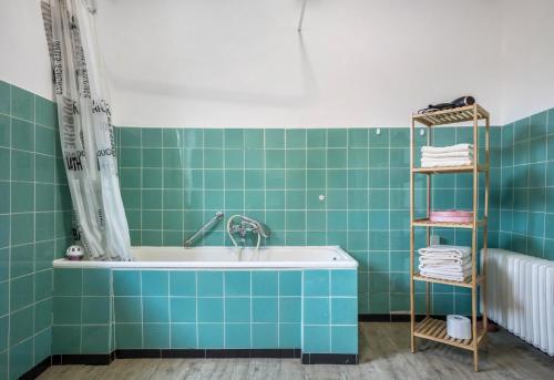 uma banheira na casa de banho com azulejos verdes em Ferienwohnung Bartölke em Bockenem