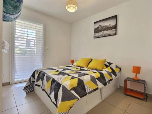 une chambre avec un lit avec des oreillers jaunes et une fenêtre dans l'établissement Yor, à Sérignan