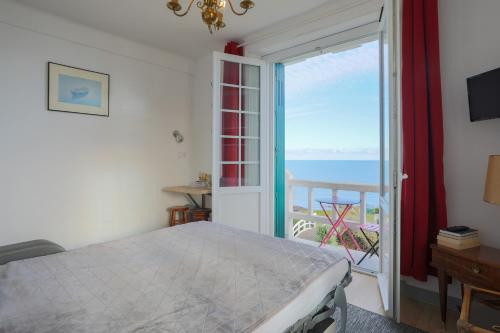 um quarto com uma cama e vista para o oceano em Studio vue mer directe 2 personnes em Saint-Quay-Portrieux