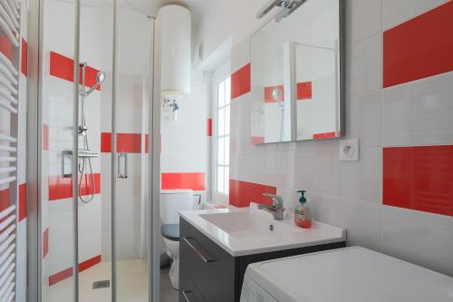 een badkamer met een wastafel, een toilet en een spiegel bij Studio vue mer directe 2 personnes in Saint-Quay-Portrieux