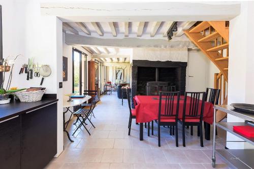 une cuisine et une salle à manger avec une table et des chaises rouges dans l'établissement Maison Gabrielle, à Varengeville-sur-Mer