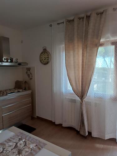 a room with a window and a clock on the wall at Appartamento turistico Olivella in Formia