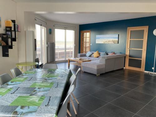 un salon avec une table et un canapé dans l'établissement Appart en Mer, à Quiberville
