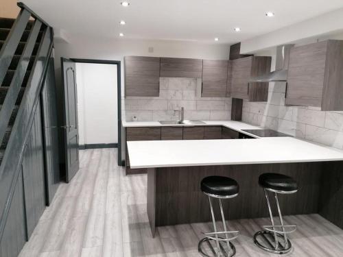a kitchen with a counter and two stools in it at Adoniapro Clacton Lodge in Great Clacton