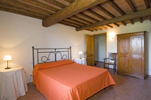 1 dormitorio con 1 cama grande de color naranja y 2 mesas en Agriturismo Campo Lungo, en San Donato in Poggio