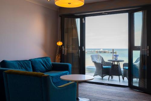 a living room with a couch and a view of the ocean at St George's Hotel - Llandudno in Llandudno