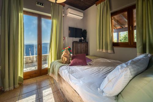 a dog sitting on a bed in a room with a window at Rock Dandy Deluxe Chalet in Arachova - Delphi, Sauna, Prv Parking, Amazing View in Arachova