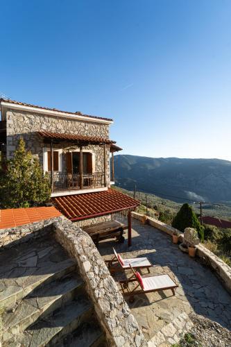 a house with a patio and a table and chairs at Rock Dandy Deluxe Chalet in Arachova - Delphi, Sauna, Prv Parking, Amazing View in Arachova