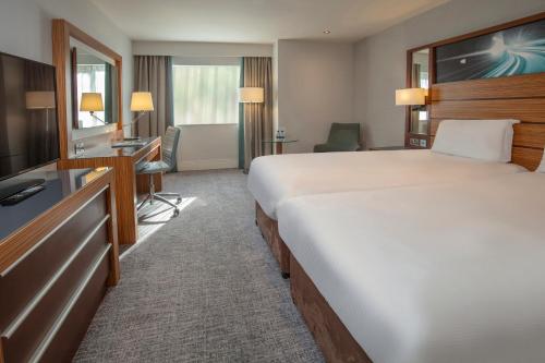 a hotel room with a bed and a flat screen tv at Ashford International Hotel & Spa in Ashford