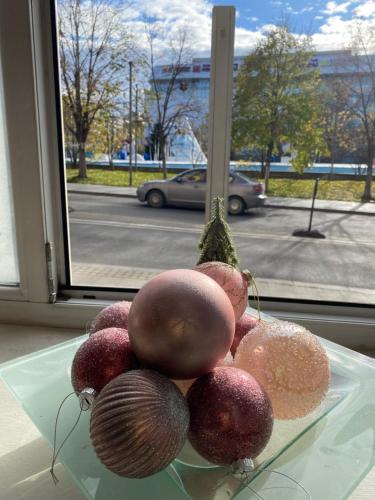 une pile de fruits sur une plaque de verre sur une fenêtre dans l'établissement Vintage Apartament Ultracentral, à Craiova