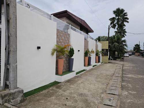 a white building with potted plants on a street at Suna' a Home Bonapriso in Douala