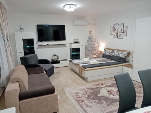 ein Wohnzimmer mit einem Bett und einem Weihnachtsbaum in der Unterkunft Hangjegy Apartman in Debrecen