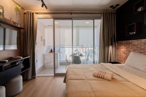 een slaapkamer met een groot bed en een balkon bij Apartamento 1106 em condomínio de alto padrão in Guarulhos