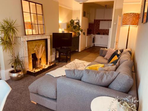 a living room with a couch and a fireplace at Stunning seafront apartment in Brighton & Hove