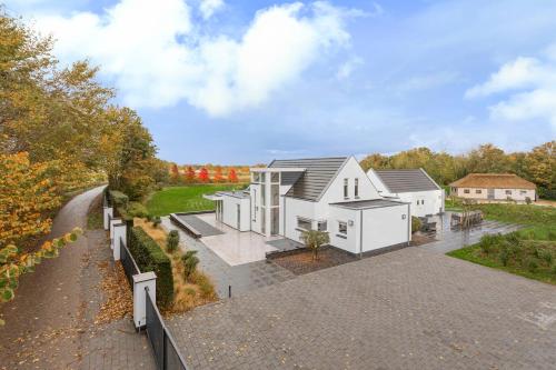 an aerial view of a white house with a driveway at Landgoed Hermitage - Villa Minerva - XXL Zwemspa - max 16 personen in Ouddorp