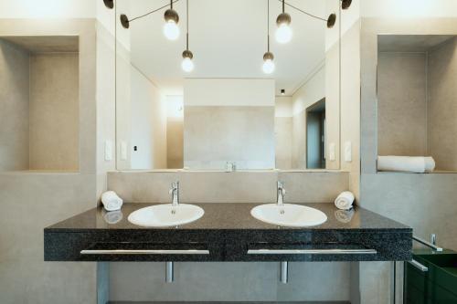 a bathroom with two sinks and a large mirror at The Garden Suites by Suite030 in Berlin