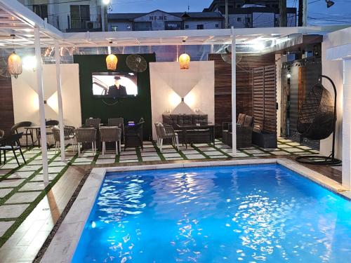 a swimming pool with a tv in a house at Suna' a Home Bonapriso in Douala