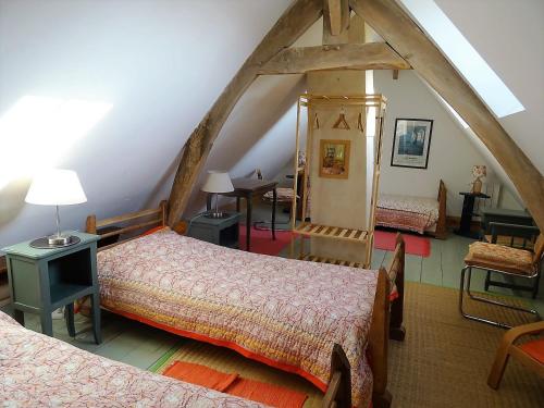 een zolderkamer met 2 bedden en een tafel bij Ecuries de Coqueretaumont in Varengeville-sur-Mer